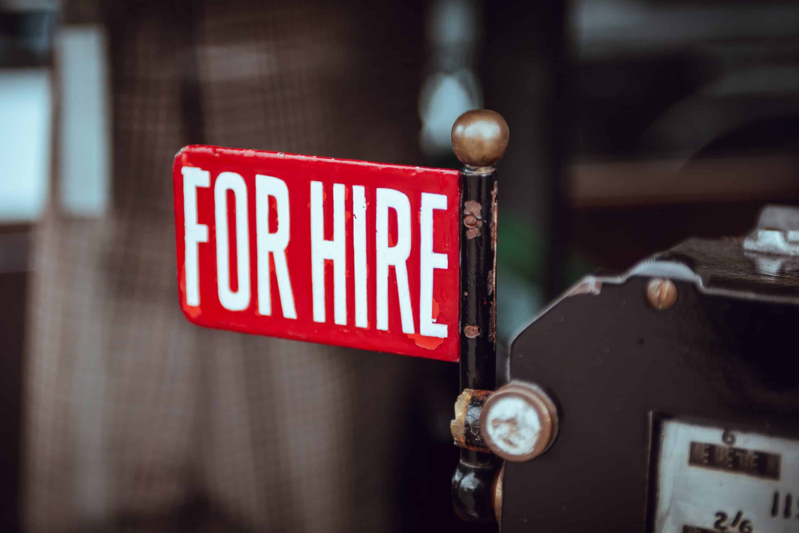 Image of a small, red "For Hire" sign