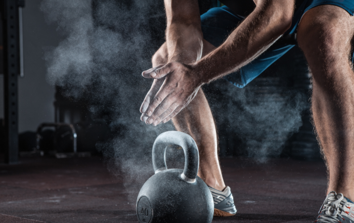 Image of someone picking up a kettle bell.