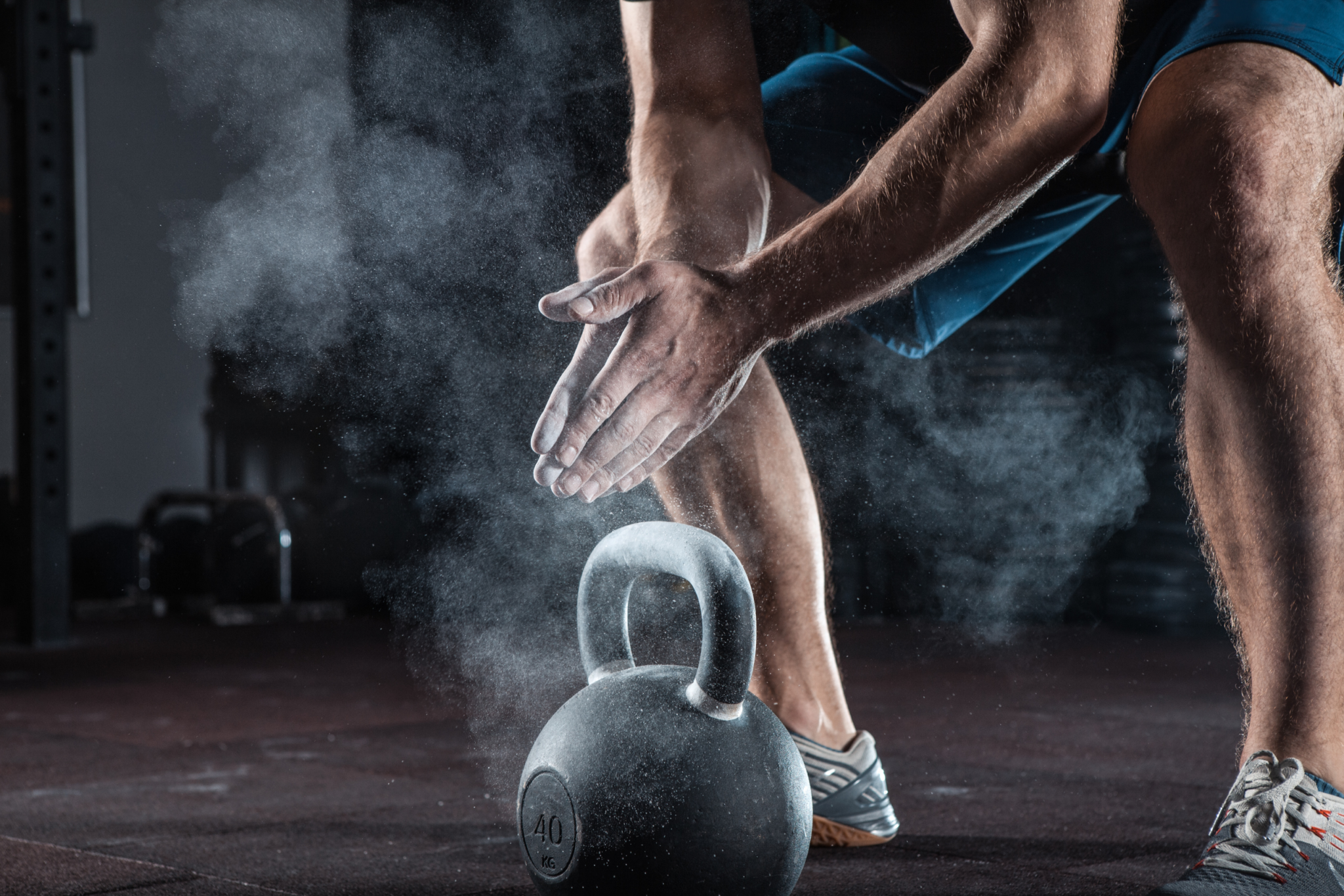 Image of someone picking up a kettle bell.