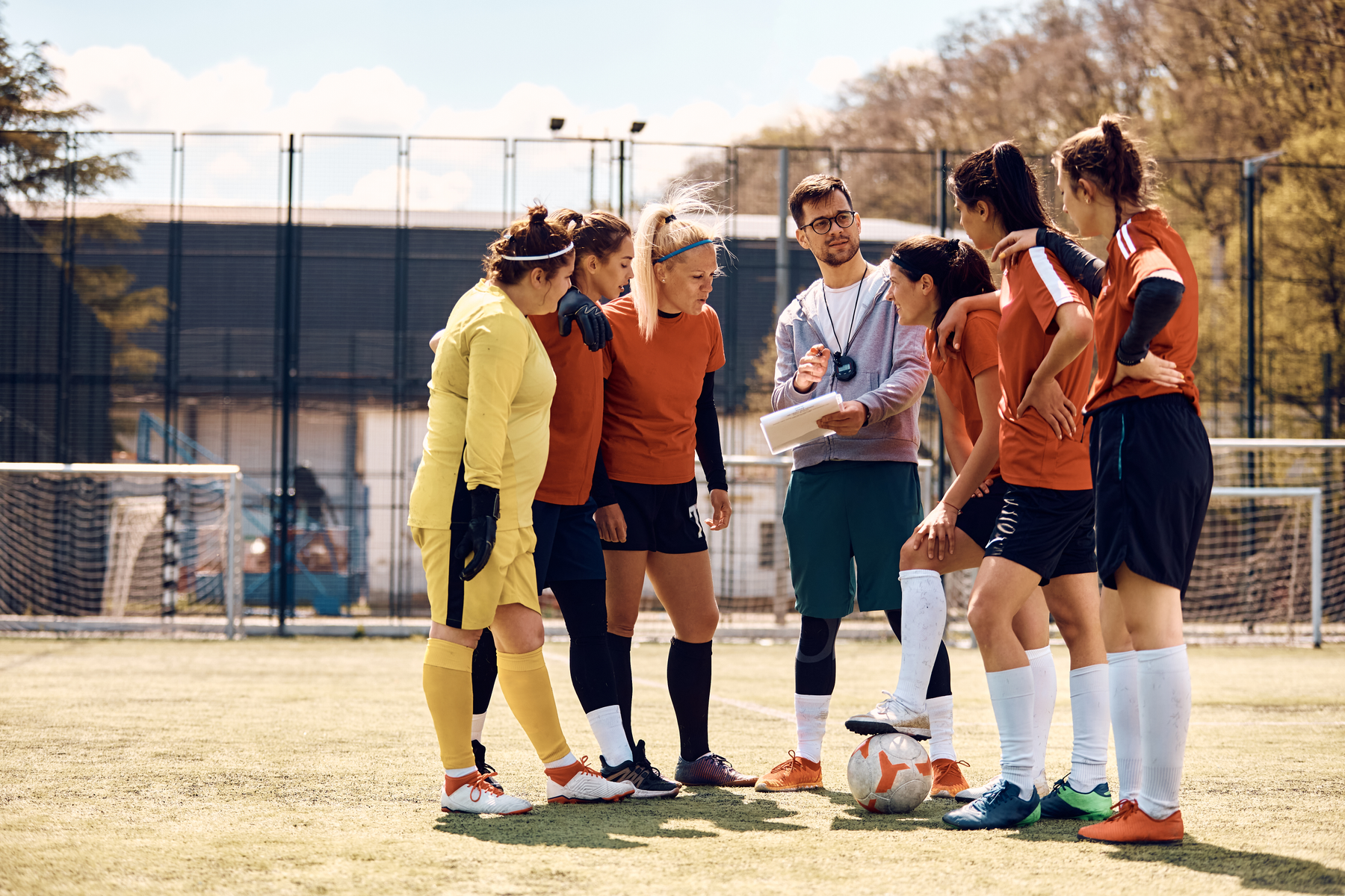 female soccer team with their coach on the field
